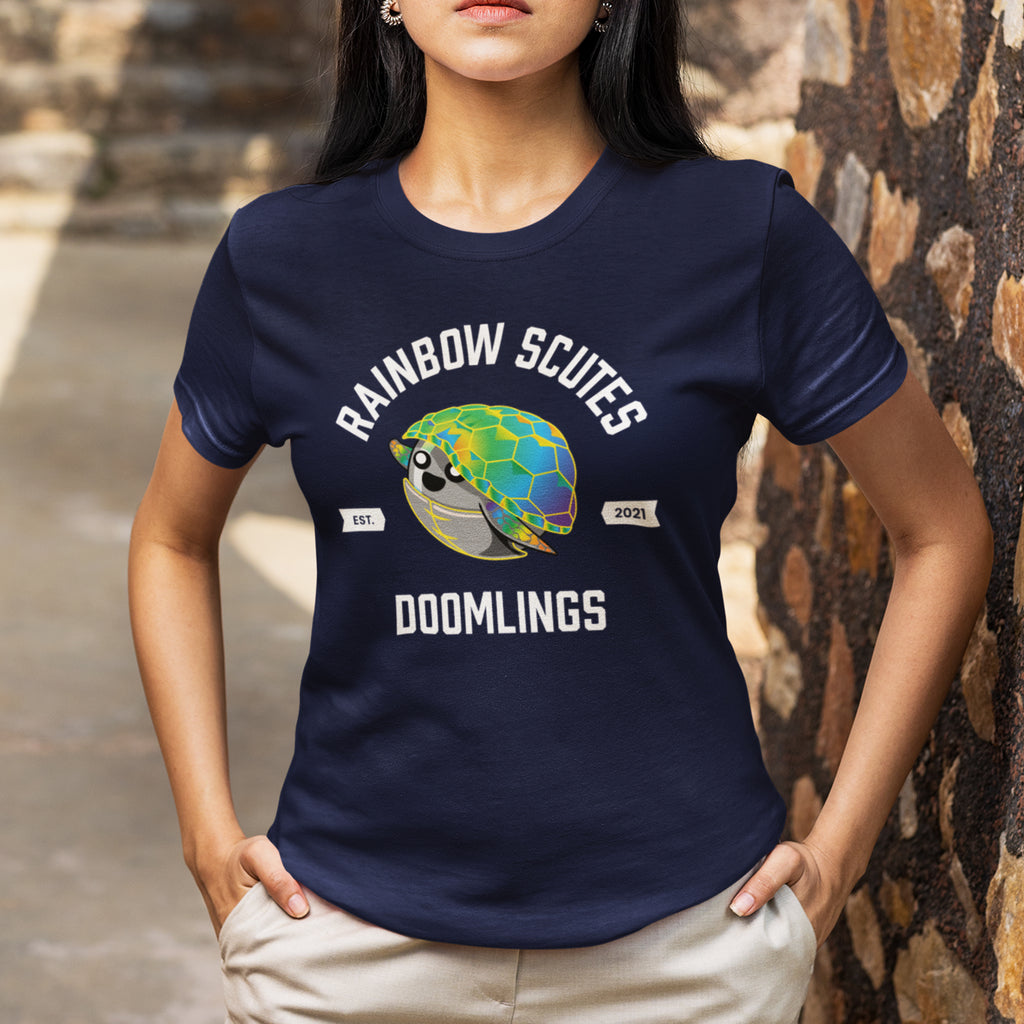 woman wearing rainbow scutes college tee, navy t-shirt, text says 'rainbow scutes doomlings est. 2021'